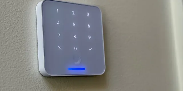 UniFi Access keypad reader with a blue light bar on a wall