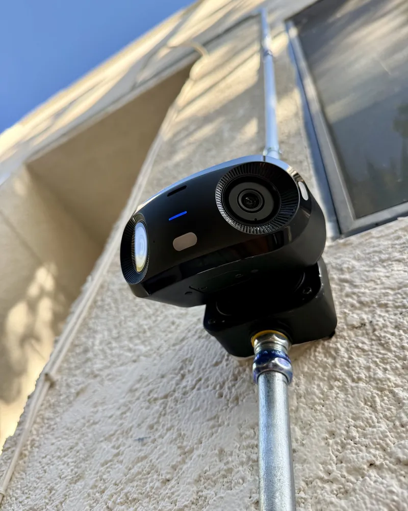 Dual-lens camera on a stucco wall
