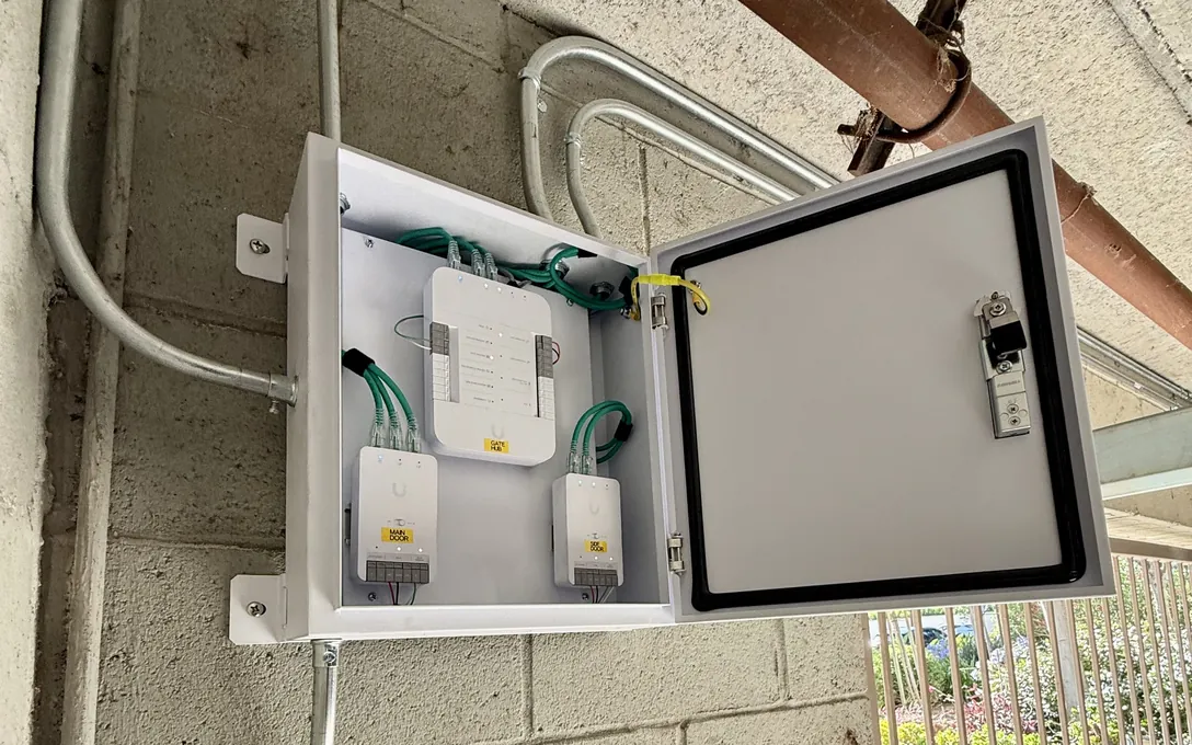 Three labeled UniFi Access hubs in a weatherproof enclosure