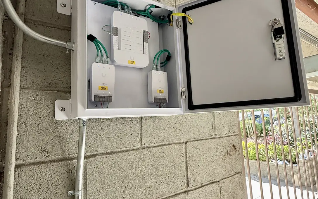 Three labeled UniFi Access hubs in a weatherproof enclosure
