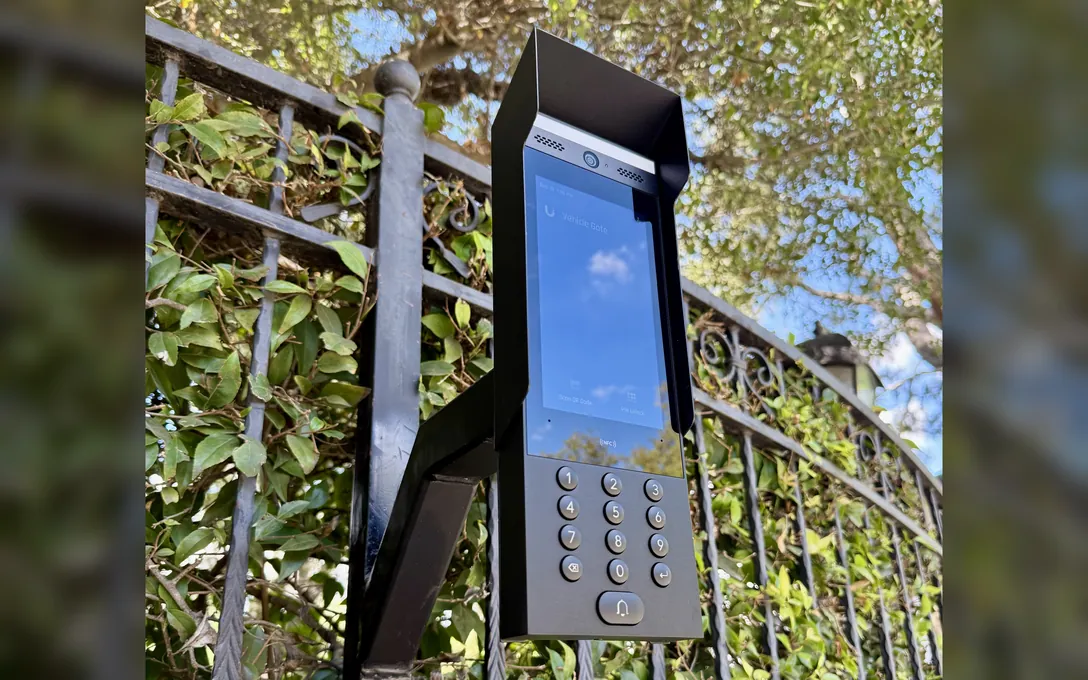 UniFi intercom with keypad mounted on an iron driveway gate