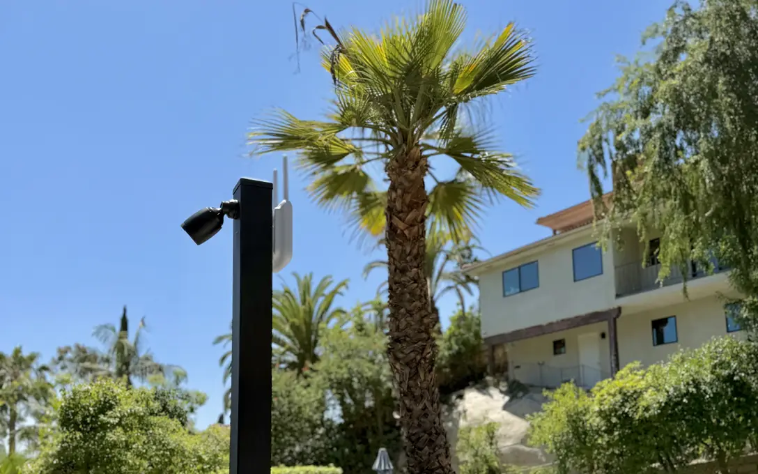 UniFi camera and access point on a black post