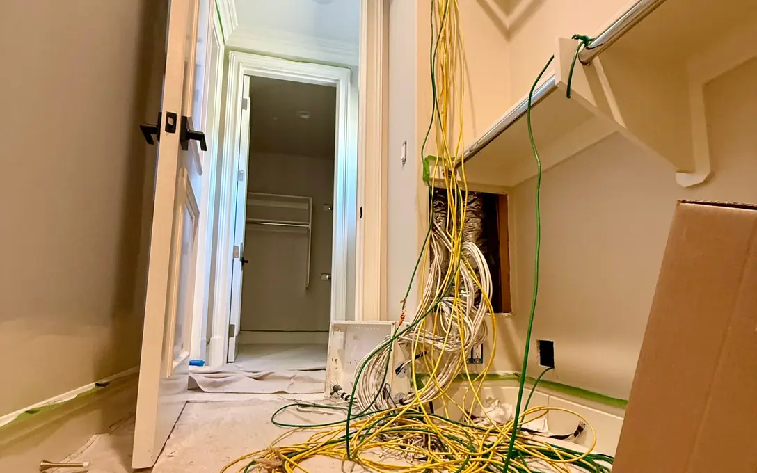 Old cables hanging from a closet wall opening