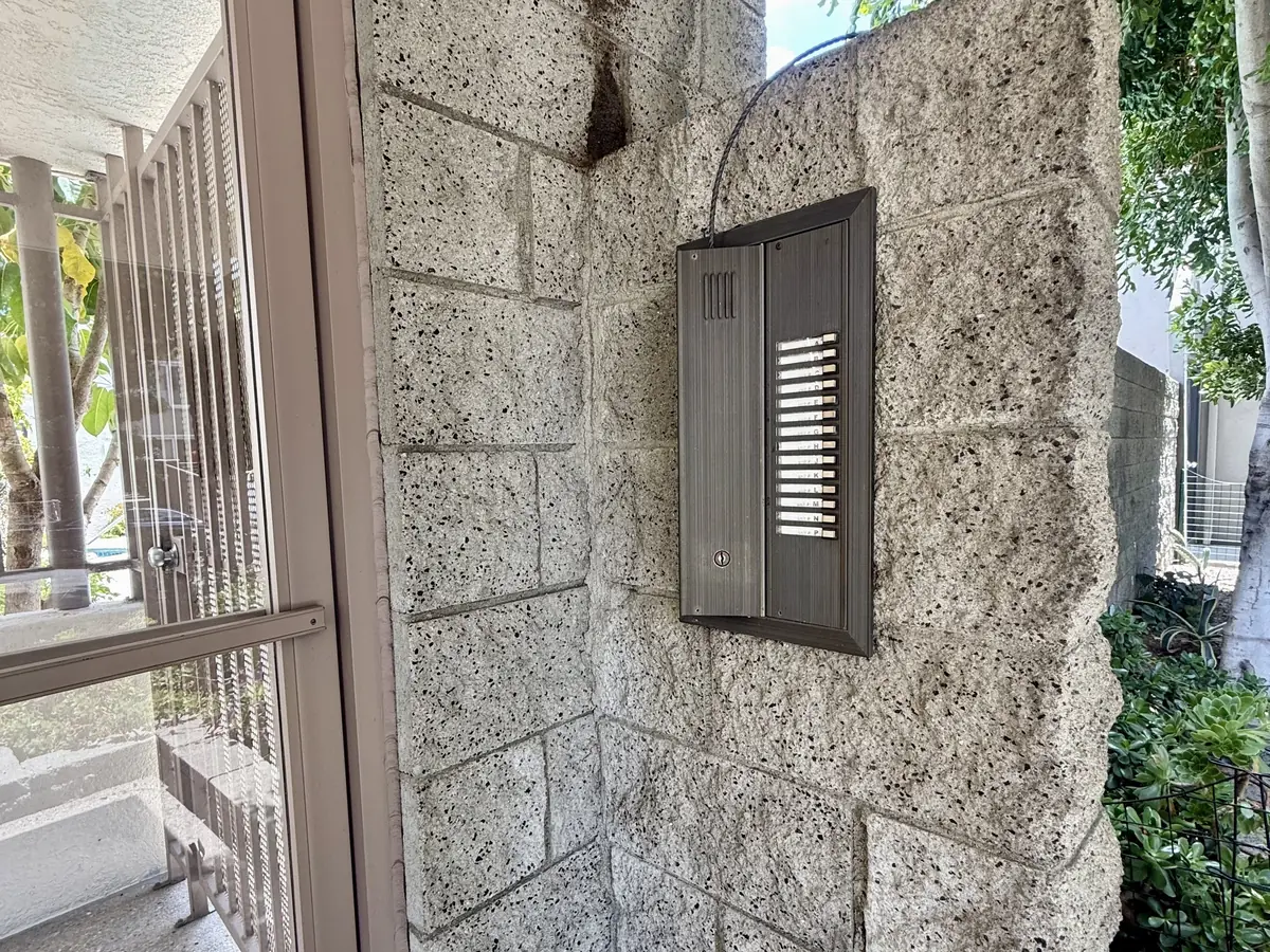 Old multi-button intercom on a block pillar