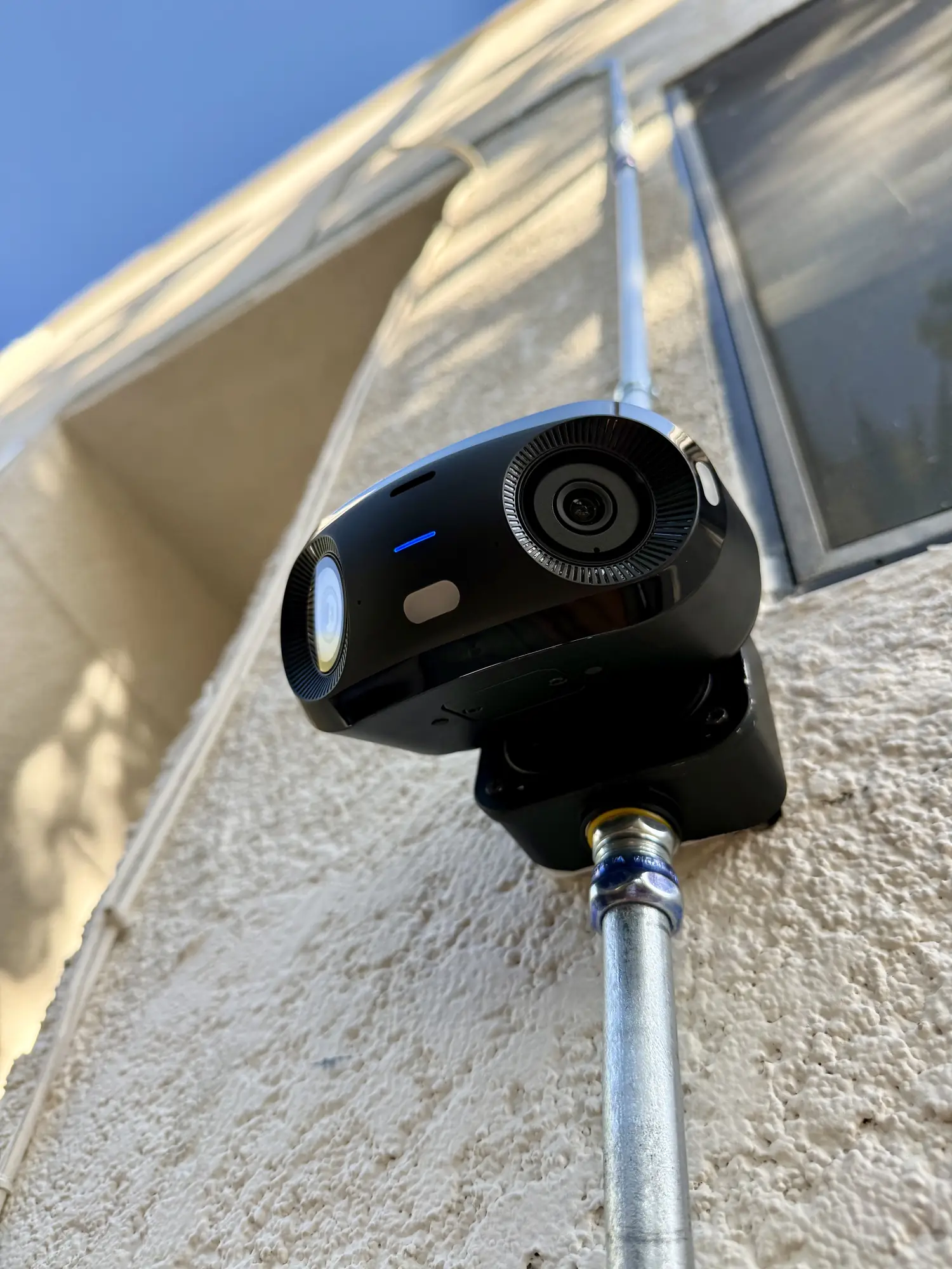 UniFi camera on a junction box on a stucco wall