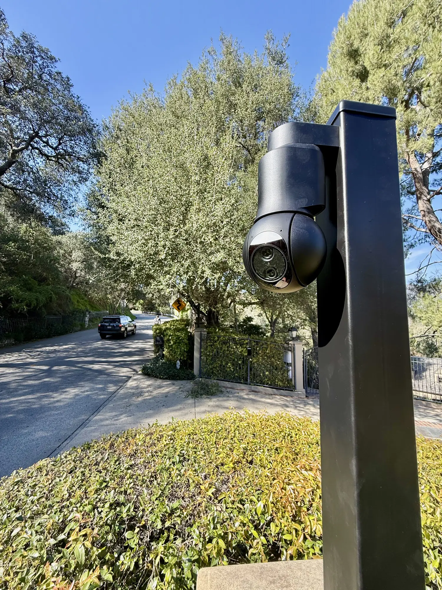 Dual lens camera on a post aimed down the road