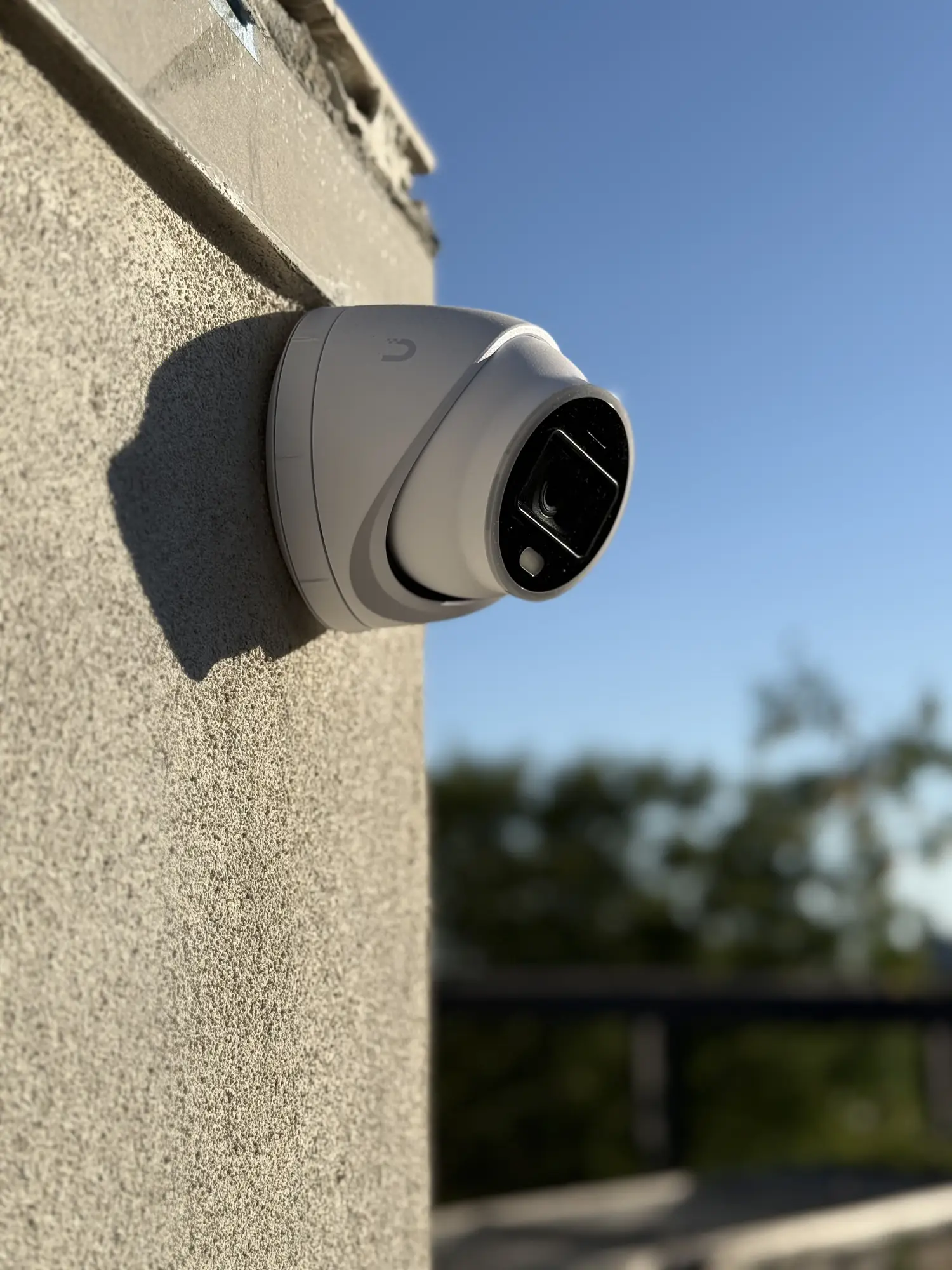 UniFi turret camera on a stucco wall