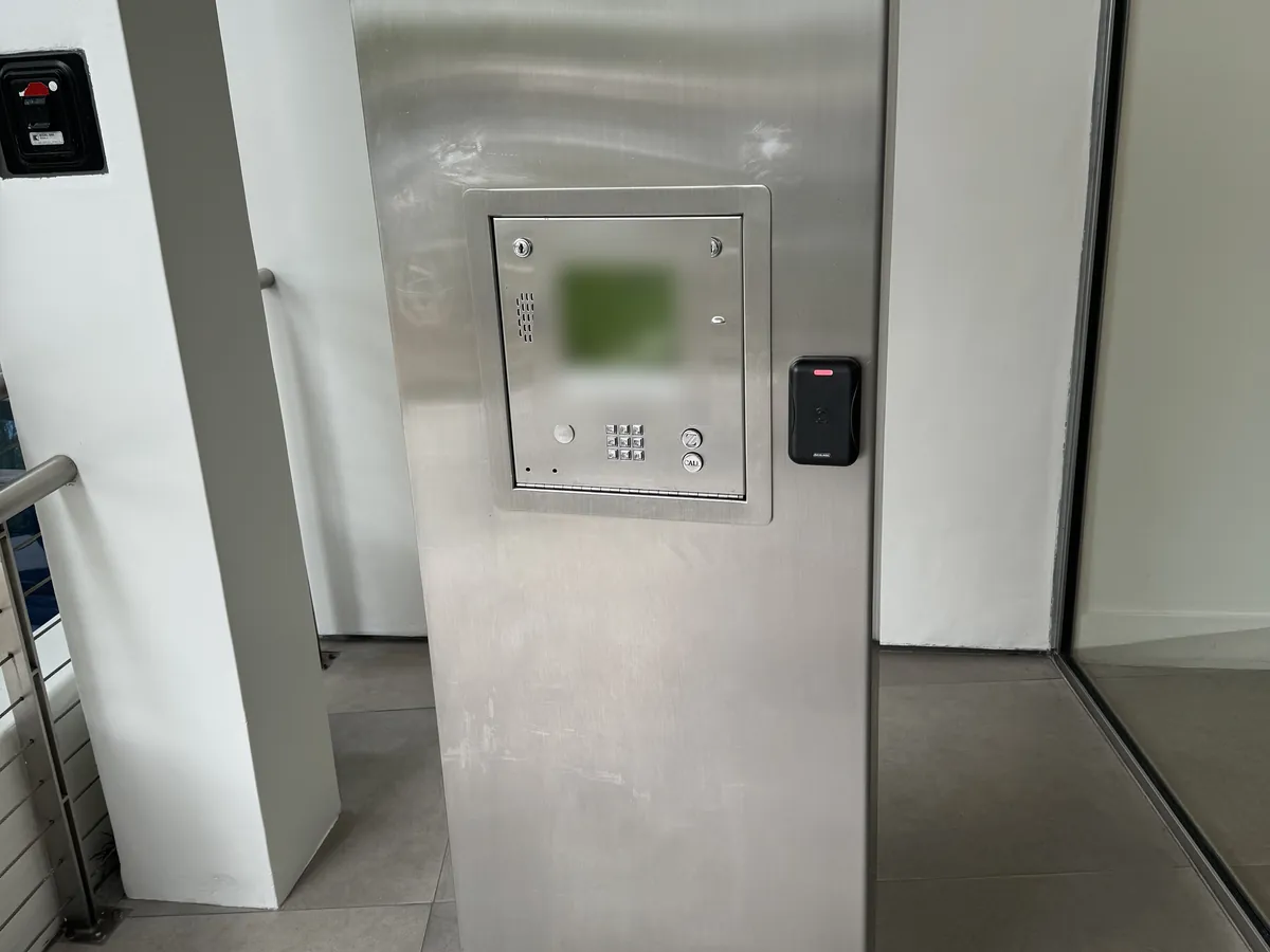 Old DoorKing telephone entry unit in a stainless steel pedestal