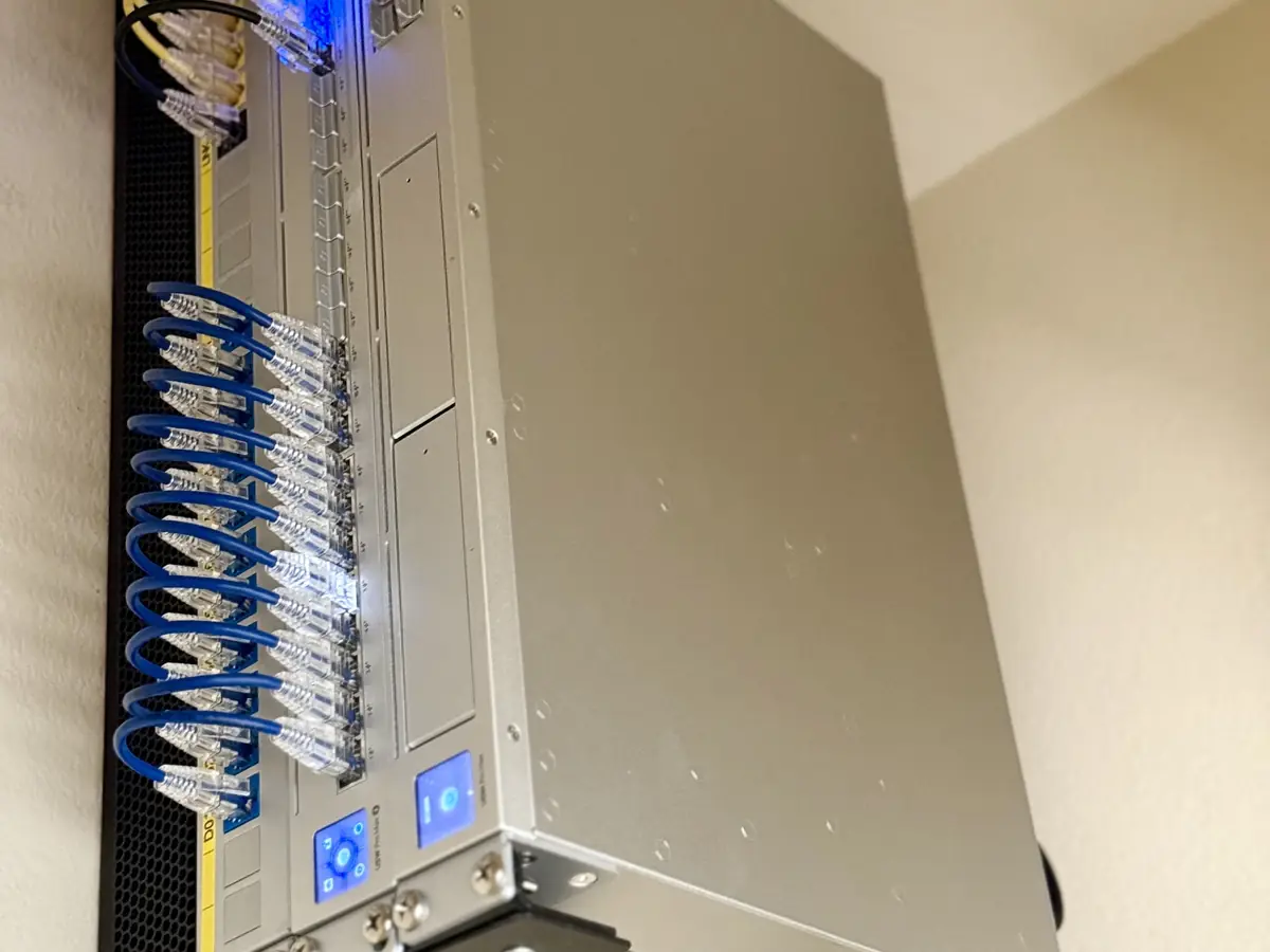 UniFi gateway and switch on a vertical wall bracket