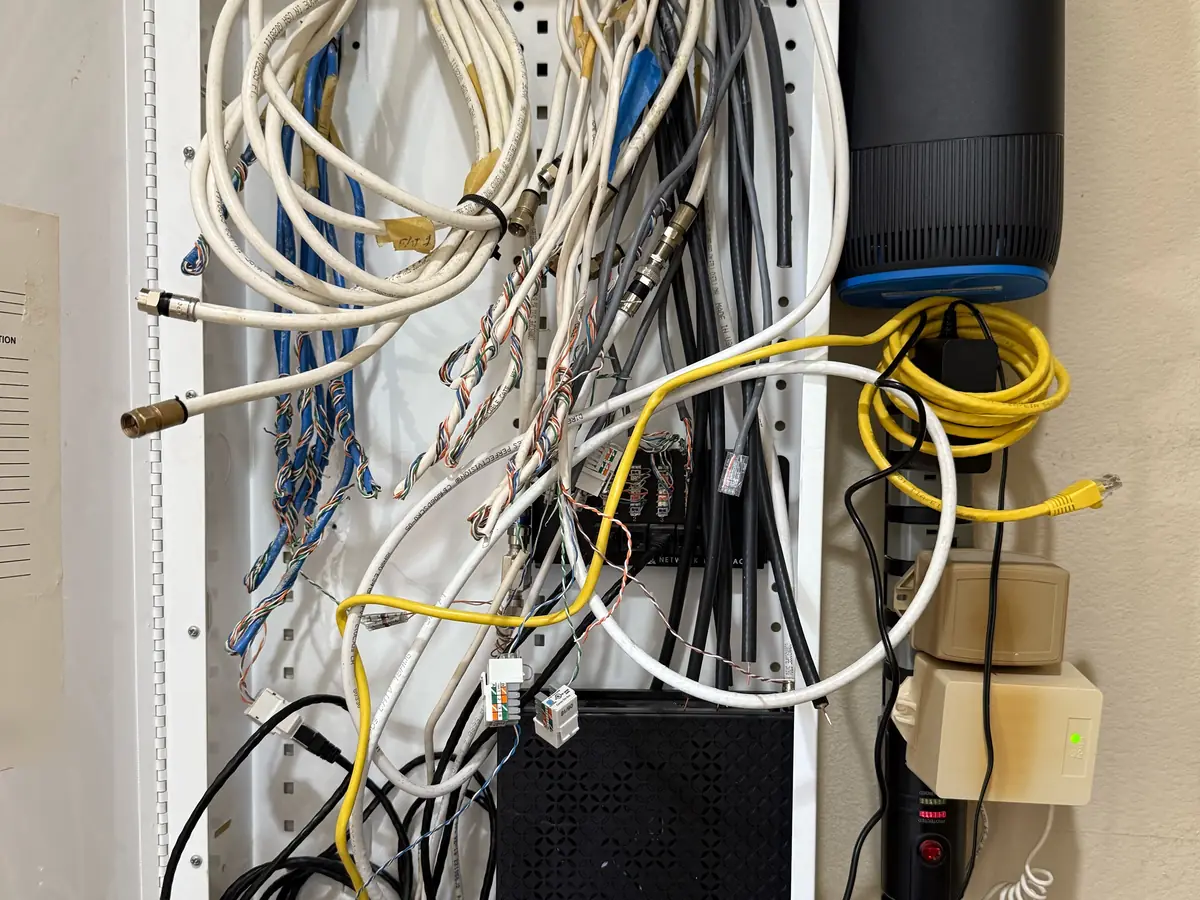 Old media cabinet with tangled cable and a Spectrum modem
