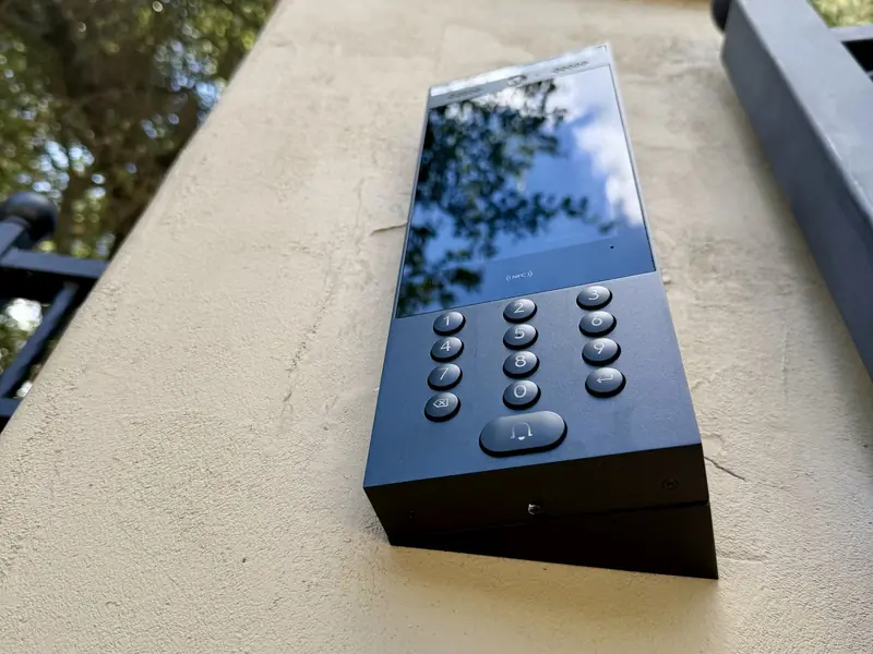 Intercom on a stone pillar beside a gate