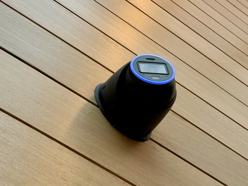 Black UniFi turret camera on wood siding