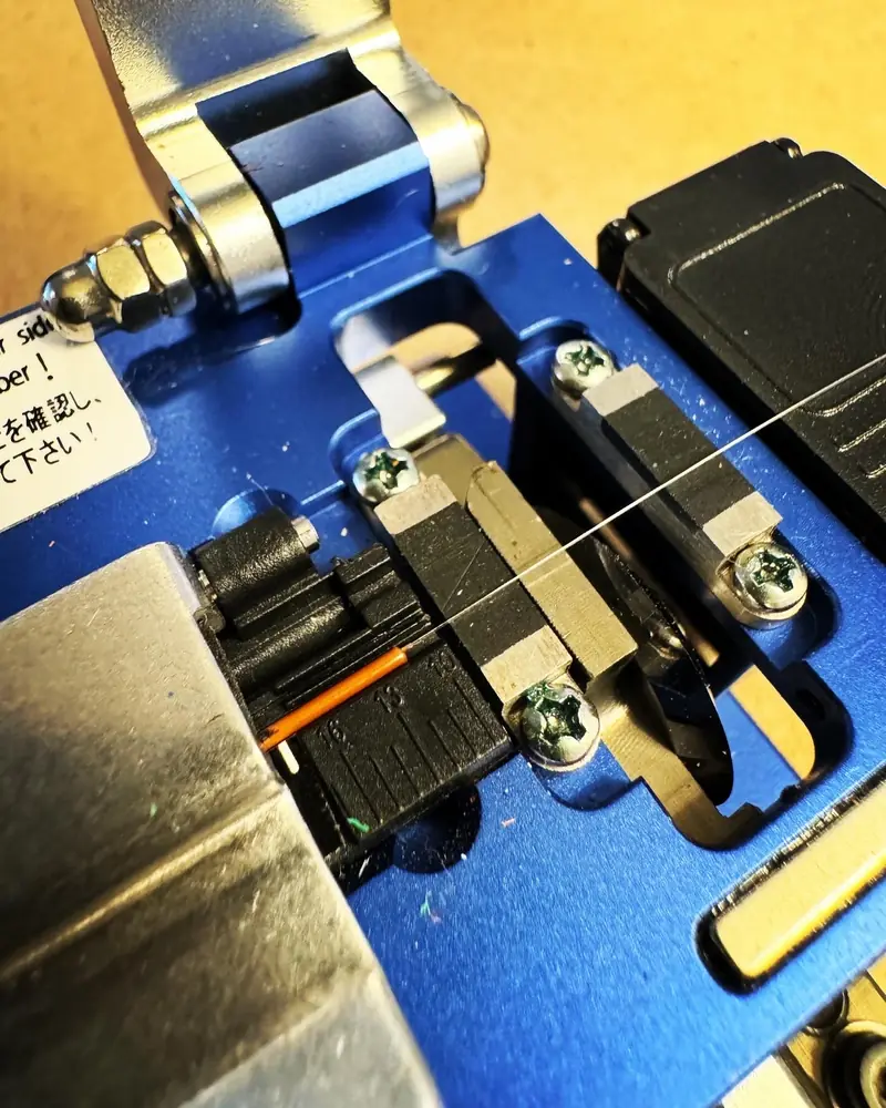 Fusion splicer holding a bare fiber during a splice