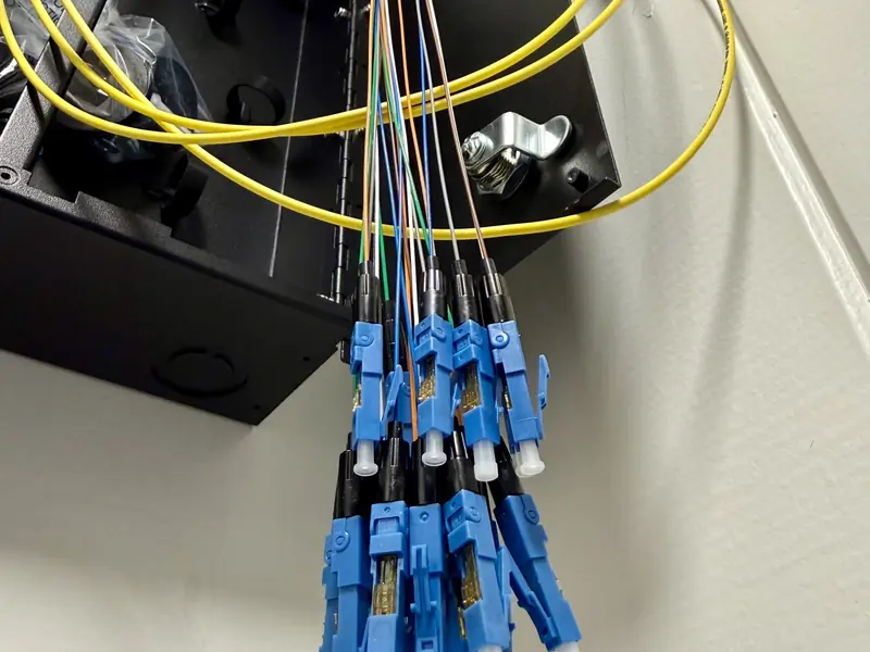 Fiber enclosure with blue LC connectors on a wall