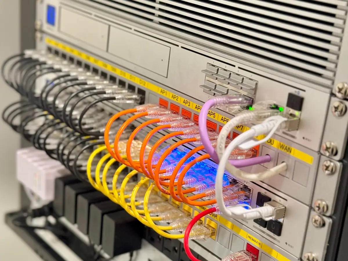 UniFi rack with yellow and orange patch cables and labeled WAN ports