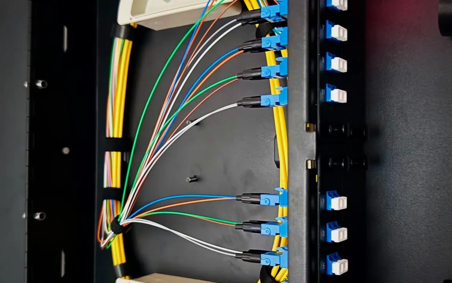 Rack-mount fiber enclosure with coiled fiber