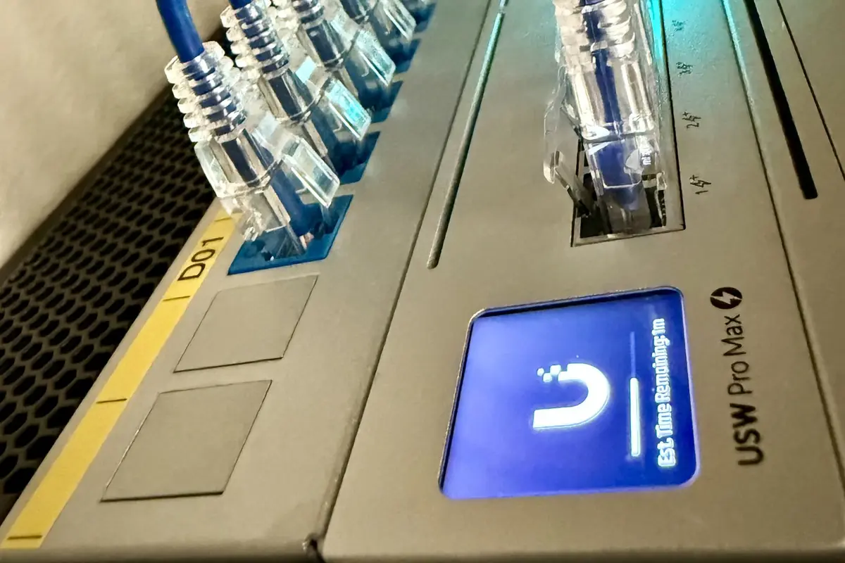 UniFi Switch Pro Max with blue patch cables and its front display
