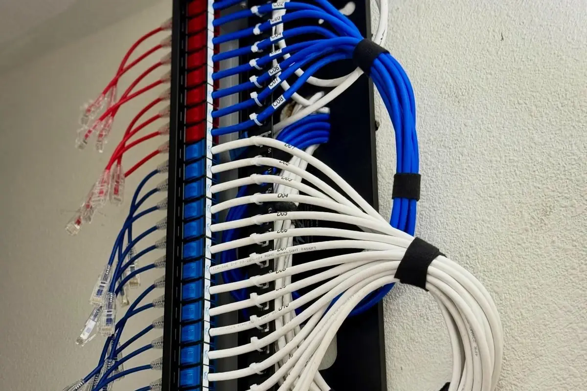 Wall-mounted patch panel with neatly bundled blue and white cables