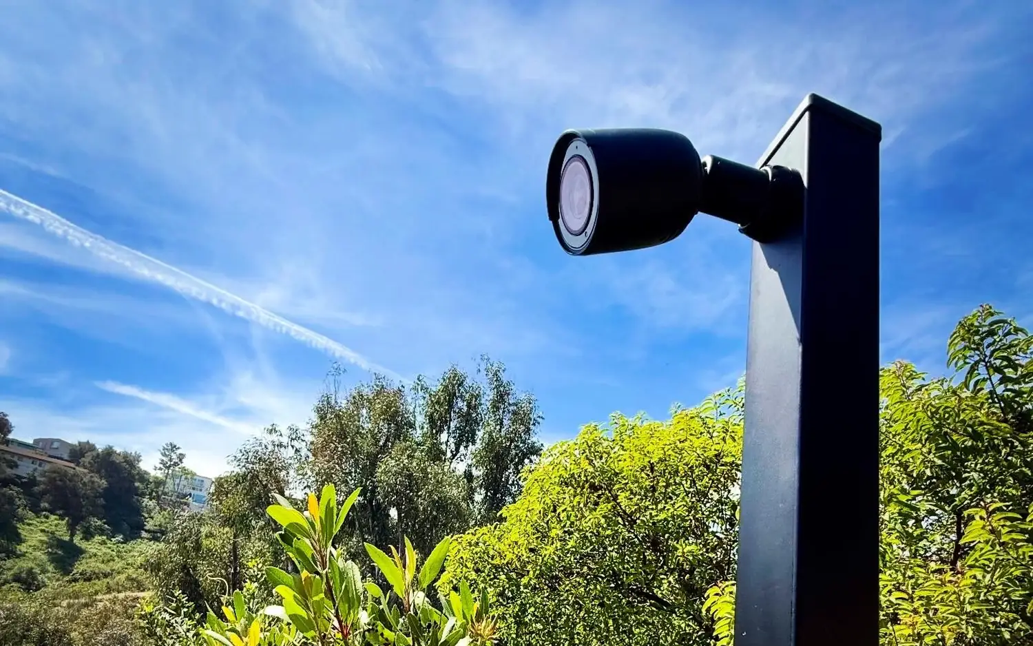 Camera on a tall black metal post on a hillside