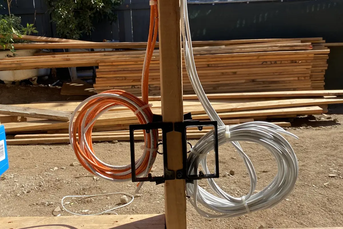 Cable coils zip tied to a wall stud at a construction site