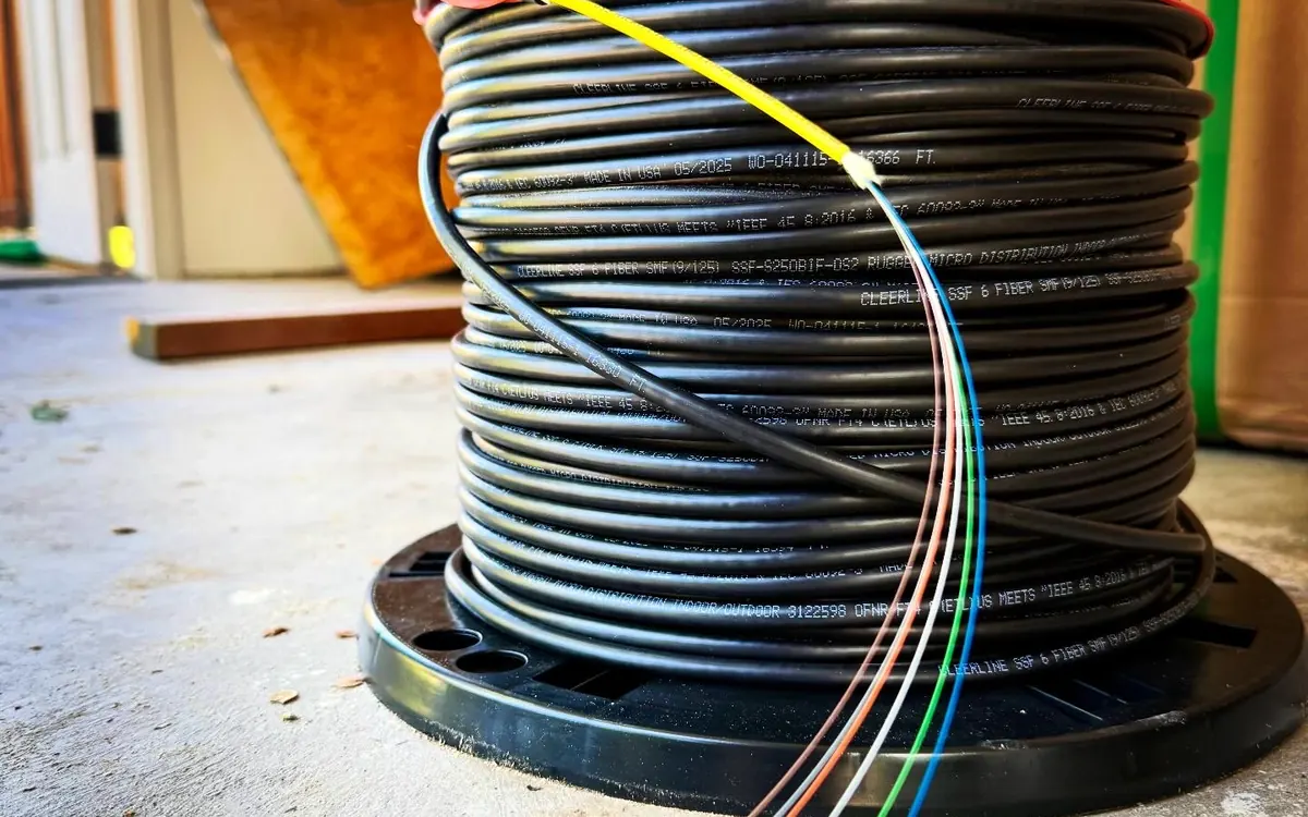 Spool of black cable on a concrete floor