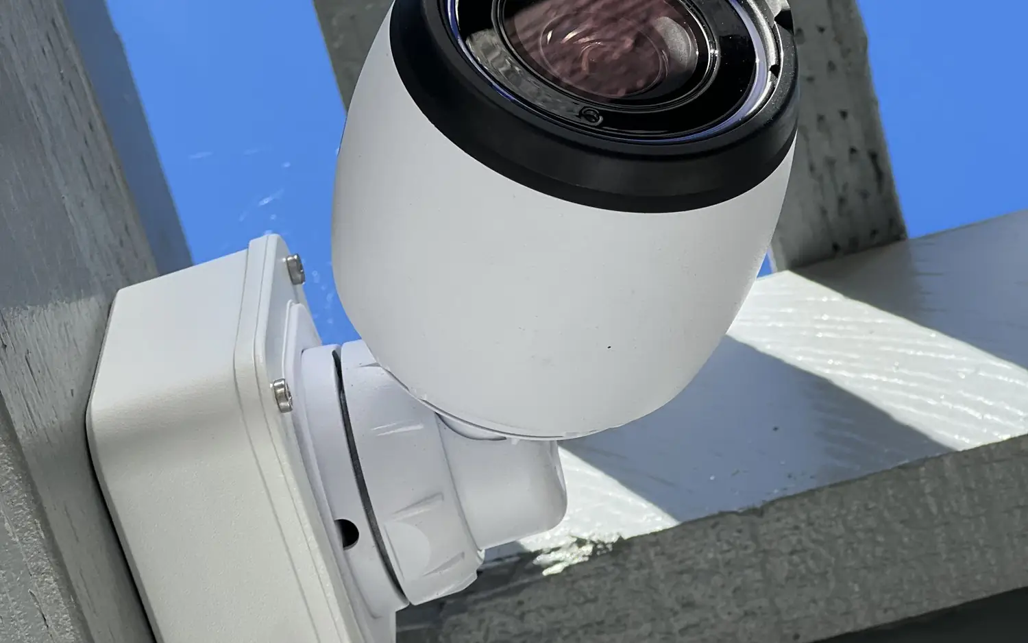 White bullet camera on a wooden beam