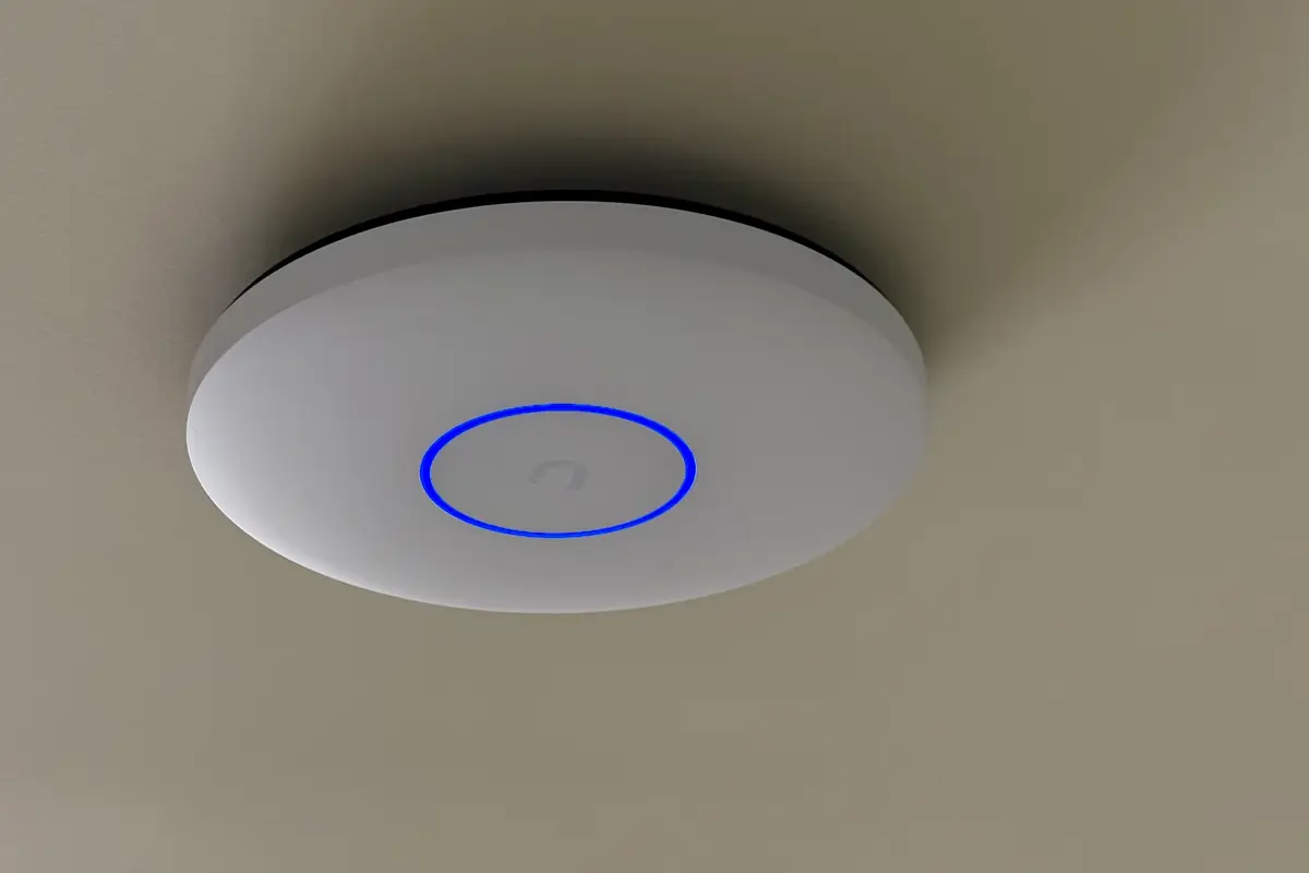 UniFi U7 Pro XG access point with a blue ring on a ceiling